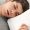Handsome young man sleeping in bed at home
