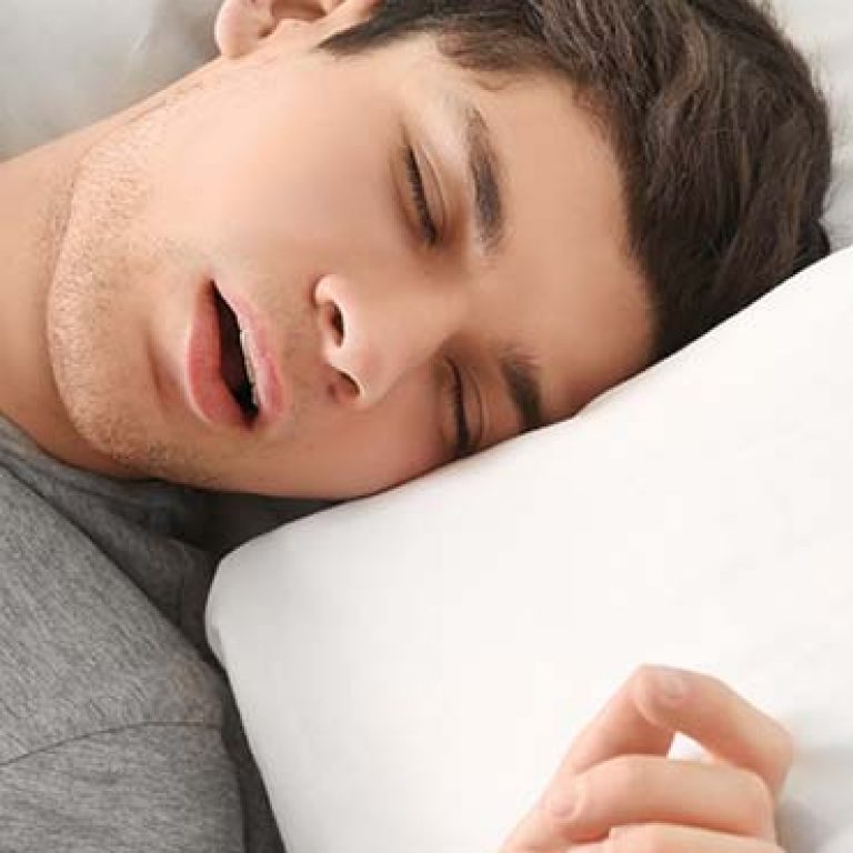 Handsome young man sleeping in bed at home